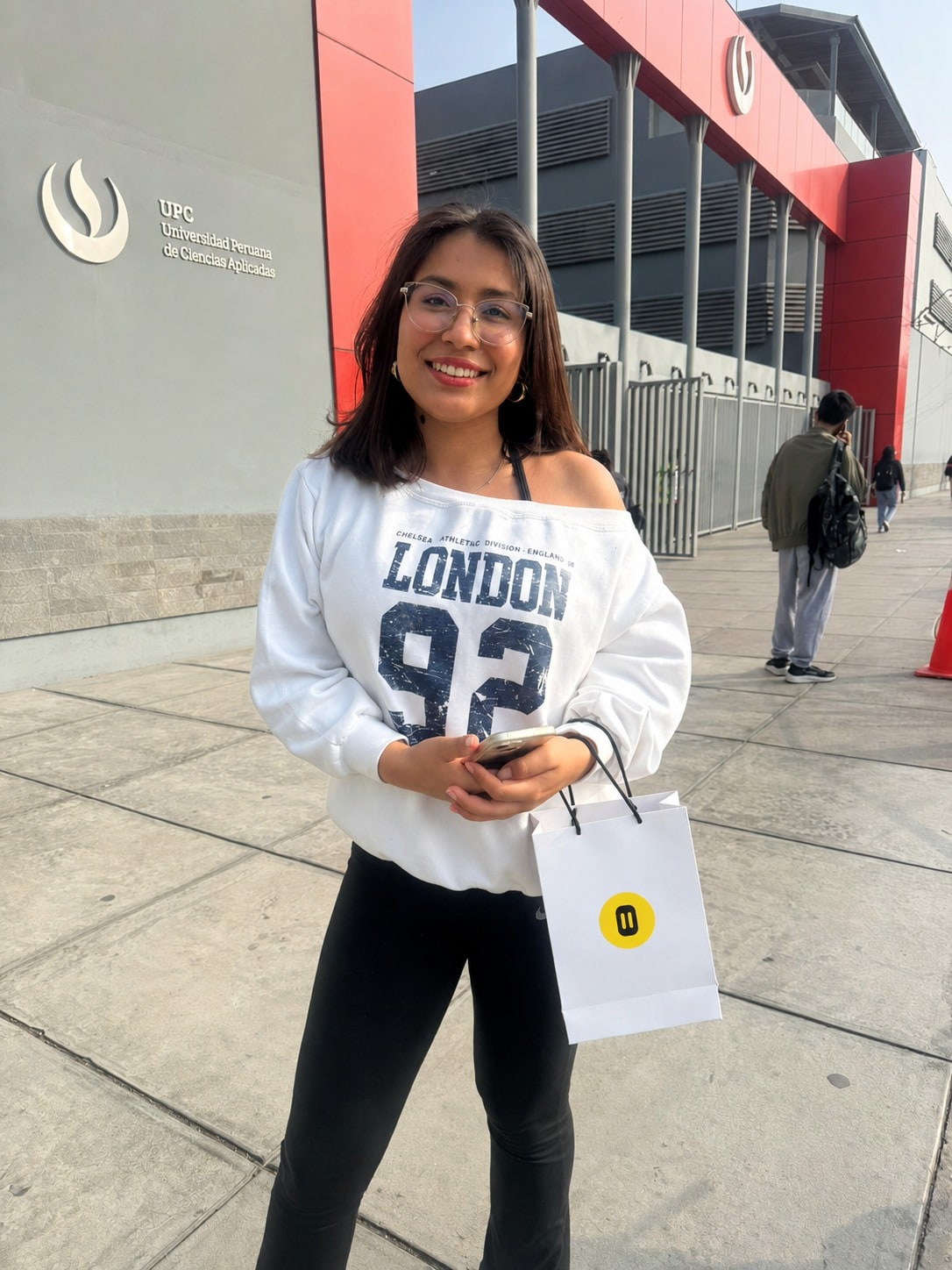 Clienta con su bolsa Inova Tech frente a una universidad
